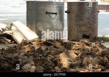 Purée de Mitti Clay mélangé avec du bois de paille de blé, de foin de Bhoosa et de l'eau saupoudrée pour préparer un pot cylindrique pour la fabrication du four indien de Clay DIY également appelé D Banque D'Images