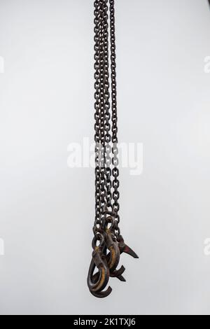 Crochets pour grue industrielle, suspendus sur des chaînes. Banque D'Images