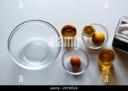 Démoulez la sauce mayonnaise maison et l'huile d'olive, les œufs, la moutarde, le citron et le bol en verre. Vue de dessus des ingrédients de la mayonnaise maison comme la moutarde, les oeufs, s Banque D'Images