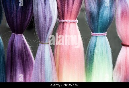 Cheveux synthétiques colorés. Fils de cheveux artificiels colorés à attacher et tresser les tresses en vacances. Banque D'Images