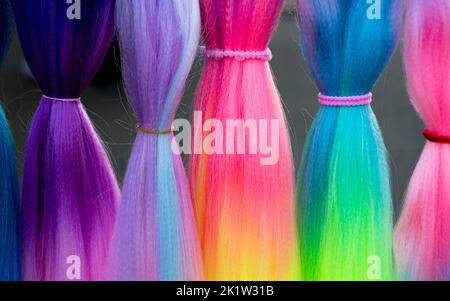 Cheveux synthétiques colorés. Fils de cheveux artificiels colorés à attacher et tresser les tresses en vacances. Banque D'Images