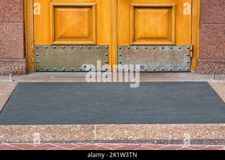 seuil en pierre avec tapis de sol à la porte d'entrée en bois et en granit façade en pierre revêtement de l'ancien bâtiment d'architecture vue de face sur c Banque D'Images