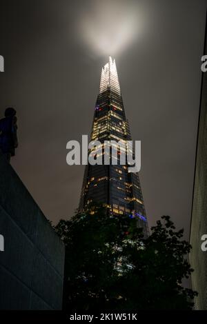 Une photo en petit angle du Shard la nuit avec des lumières contre un ciel noir Banque D'Images