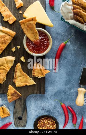 Un petit bol de gelée de piment maison servi avec des biscuits croustillants à la tortilla. Banque D'Images