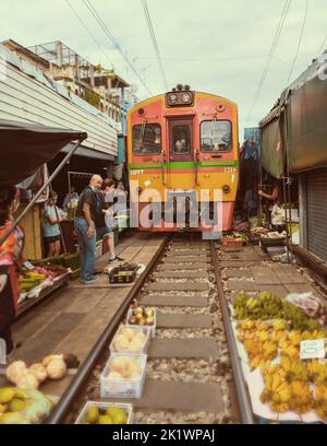 Marché ferroviaire de Maeklong Thaïlande, . Entraînez-vous sur des chenilles qui se déplacent lentement. Marché frais de parasol sur la voie ferrée, gare de Mae Klong, Bangkok, Thaïlande, un jour ensoleillé Banque D'Images