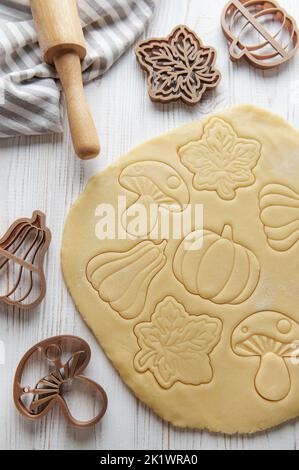 Cuisson de biscuits sous forme de citrouille et de feuilles. Pâtisserie d'automne confortable. Pâte avec emporte-pièces. Banque D'Images