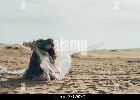 Abus féminin. Silhouette défoqué. Harcèlement violence. Femme épuisée perturbée victime dans le noir s'échappant du film de polyéthylène transparent piégé Banque D'Images