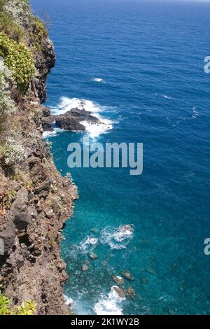 Falaises abruptes de la côte nord de Madère avec des vagues s'écrasant sur les rochers vus de Vau da Noiva Banque D'Images