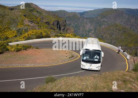 Autocar blanc qui navigue dans un virage en épingle à cheveux sur la route ER202 sur la montagne Pico do Arieiro dans le centre de Madère Banque D'Images