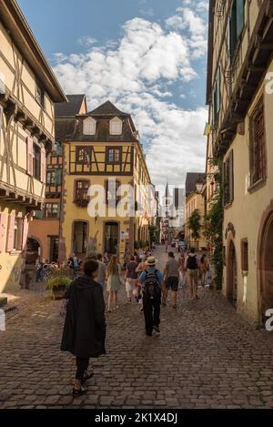 Personnes dans la rue du village médiéval de Riquewihr, Alsace, France Banque D'Images