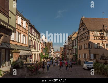 Personnes dans la rue du village médiéval de Riquewihr, Alsace, France Banque D'Images