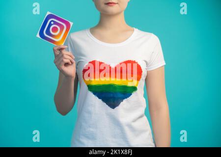 Kharkiv, Ukraine - 27 novembre 2020 : icône Instagram. Médias sociaux. Application mobile. Communauté en ligne. Femme au coeur comme un t-shirt main tenant l'application Banque D'Images