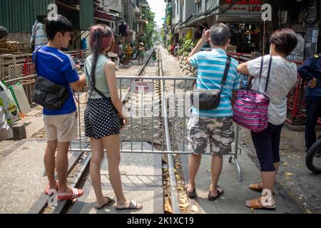 19 septembre 2022, Vietnam, Hanoï: Les touristes prennent des photos à une barrière dans la 'rue de train' fermée une fois de plus. Quelques mois seulement après la réouverture de la célèbre « rue du train », les autorités ont de nouveau fermé la vue. Après que l'accès a été interdit il y a trois ans pour des raisons de sécurité, les cafés et les stands le long de la route ferroviaire, qui s'étend entre des blocs étroits de maisons, ont rouvert à la suite des déloossements de Corona - attirant des visiteurs du monde entier. Dans un premier temps, la ville a laissé les touristes entrer. Il y a quelques jours, cependant, il a mis en place des barrières avec de grands signaux d'avertissement. Photo: Chris Humphr Banque D'Images