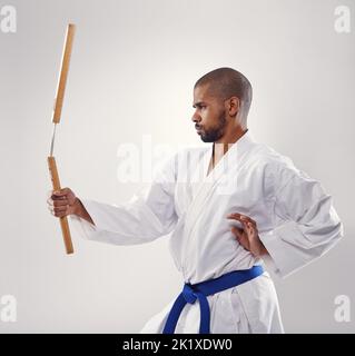 Brandissant ses punchucks comme un pro. Un homme africain qui fait du karaté. Banque D'Images