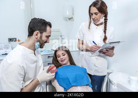 Dentist showing patient modèle à mâchoires dans une clinique dentaire Banque D'Images