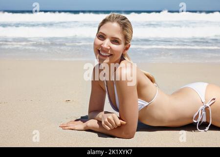 Belle vue en été. Portrait d'une belle jeune femme dans un bikini blanc profitant d'une journée à la plage Banque D'Images
