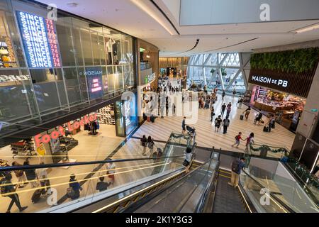 Personnes sur l'escalator dans le centre commercial de l'aéroport de Changi, Singapour Banque D'Images