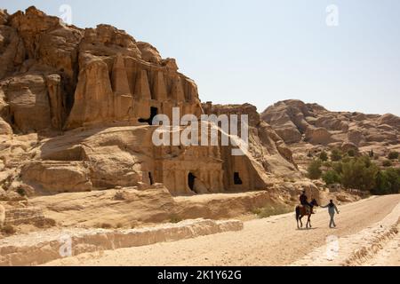 Two men on the road to Petra, near a temple built in the rock Stock Photo