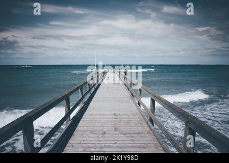 Jetée en bois sur la mer Baltique rugueuse par temps sombre et venteux, bord de mer allemand Banque D'Images