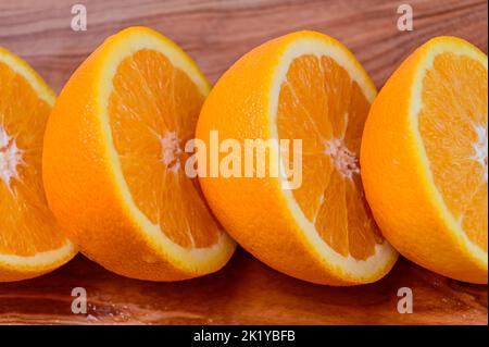 Des oranges tranchés sur un fond de bois dans une rangée Banque D'Images