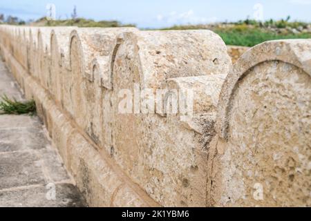 Une clôture en pierre calcaire ou une frontière décorée de petites et grandes arches en pierre autour de la chapelle Saint Dimitri dans le village rural de Gharb, Gozo, Malte Banque D'Images