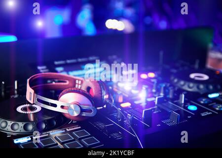 Casque DJ rose sur le mixeur et les platines en boîte de nuit Banque D'Images