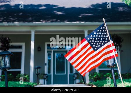 Un grand drapeau américain à l'extérieur d'une maison de style acadien de Louisiane Banque D'Images