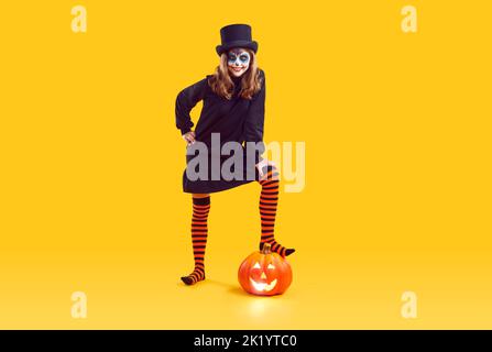 Portrait d'un enfant heureux en costume d'Halloween effrayant posé sur fond jaune de studio Banque D'Images