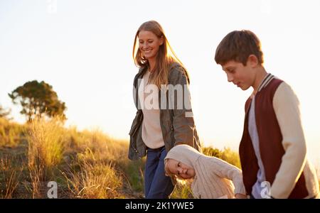 Prendre de l'air frais avec maman. Une mère heureuse sur une promenade matinale avec ses deux enfants Banque D'Images