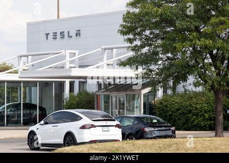 L'avant d'un concessionnaire Tesla est vu pendant la journée avec un modèle X blanc et un modèle 3 noir à l'avant, tandis qu'un véhicule de démonstration peut être vu dans le bâtiment. Banque D'Images
