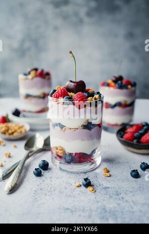 Close up of mixed berry yogurt parfait on grey background. Stock Photo