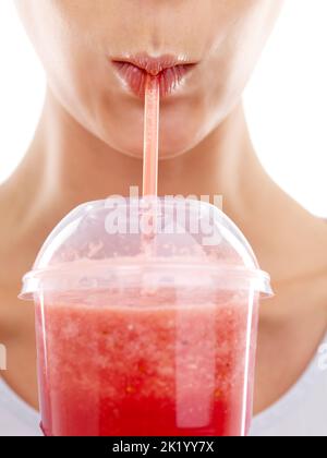 Ce smoothie est bon pour les baies. Photo studio d'une belle jeune femme en dégustant un smoothie aux fruits Banque D'Images