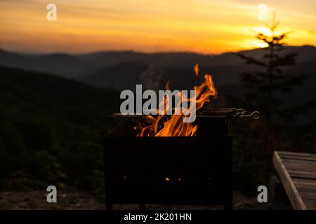 Bois brûlé la nuit. Feu de camp au camp touristique dans la nature en montagne. Flamme amd feu des étincelles sur fond abstrait foncé. Barbecue de cuisine extérieur Banque D'Images