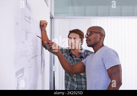 Ces mesures sont-elles correctes ? deux architectes masculins examinent et discutent des plans de construction Banque D'Images