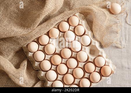 Œufs de poulet frais biologiques dans un emballage en carton ou dans un contenant en papier d'œuf sur une pile. Concept d'emballage sans déchets Banque D'Images
