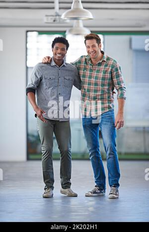 Des esprits divers pour des liens forts. Deux beaux hommes debout bras dans le bras souriant à la caméra Banque D'Images