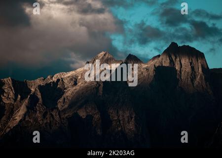 Une montagne sombre avec des rayons de soleil qui frappent le pic par une journée semi-nuageux.idéal pour un arrière-plan de bureau. Banque D'Images
