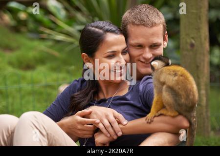 Hé regardez, c'est votre mini-moi. Un jeune couple passant du temps dans un sanctuaire d'animaux Banque D'Images