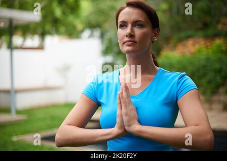 Un foyer paisible. Une jeune femme dans un yoga méditatif pose à l'extérieur. Banque D'Images