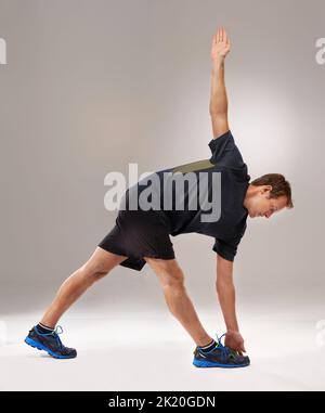 Mettre sa forme physique en marche. Photo en studio d'un jeune homme beau dans les vêtements de sport. Banque D'Images