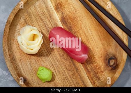 Vue de dessus des morceaux de thon sur bois et gingembre avec wasabi à couper et préparer des sushis. Banque D'Images