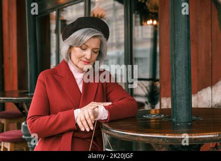 Femme âgée marchant à la table du café dans le restaurant. Vieille dame âgée à la retraite sur la rue de la ville. Elégant et élégant personne âgée retraité. Tout à fait Banque D'Images