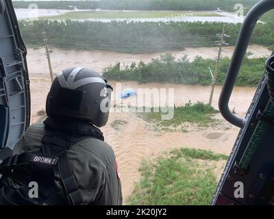 Côte sud, Porto Rico. 19th septembre 2022. Un équipage d'hélicoptère MH-60T Jayhawk de la Garde côtière de la station aérienne Borinquen vérifie la présence de signes de survivant dans un véhicule inondé sur la côte sud de Porto Rico lors du vol initial d'évaluation côtière et portuaire de la Garde côtière après l'ouragan Fiona. (Credit image: © Capt. Ricardo Castrodad/US Service de fils de presse de la Garde côtière/ZUMA) Banque D'Images