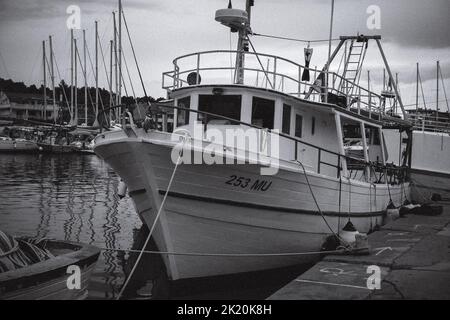 Gros plan d'un gros bateau de pêcheur en niveaux de gris, situé dans le port de Croatie Banque D'Images