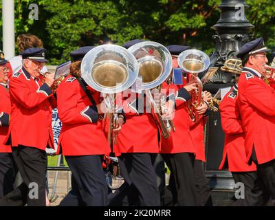 Londres Royaume-Uni 15 juin 2009; section en laiton de la bande de marching en uniforme rouge et bleu passant avec grand tuba reflétant le soleil. Banque D'Images