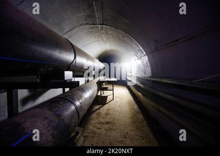 Tunnel souterrain en béton voûté d'égout, de conduit de chauffage ou de système d'alimentation en eau. Banque D'Images