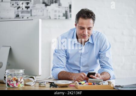 Prendre un moment pour socialiser. Un beau homme d'affaires dans son bureau Banque D'Images