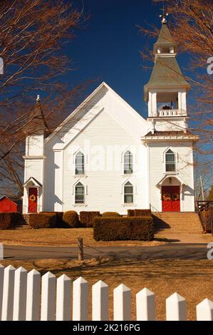 Une petite église de campagne est entourée d'une clôture de piquetage blanche le jour du soleil Banque D'Images