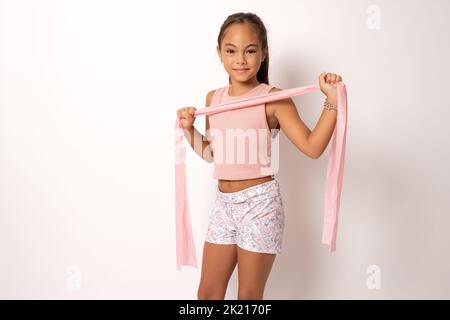 La gymnaste de fille d'enfant démontre la flexibilité ficelle debout isolée sur fond blanc. Banque D'Images