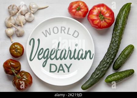 Cadre de légumes biologiques sur une table en bois avec une assiette blanche pour l'alimentation et l'inscription Journée mondiale de la végétarienne. Dessus avec cousu plat Banque D'Images